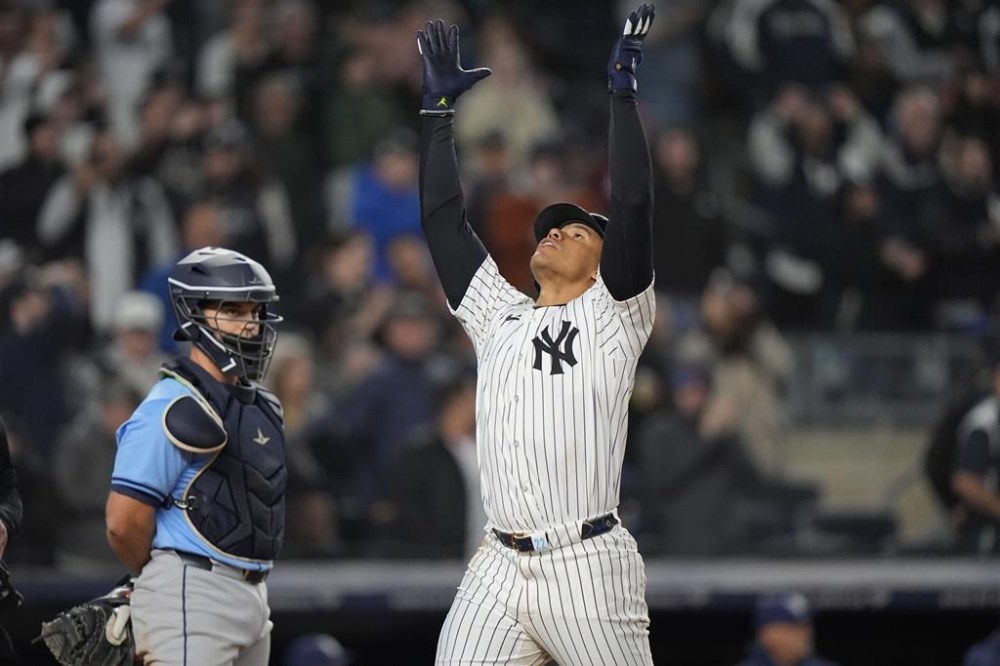 New York Yankees' Juan Soto, right, celebrates as he reaches home plate after hitting a three-run home run during the seventh inning of a baseball game as Tampa Bay Rays catcher Ben Rortvedt watches Friday, April 19, 2024, in New York. (AP Photo/Frank Franklin II)