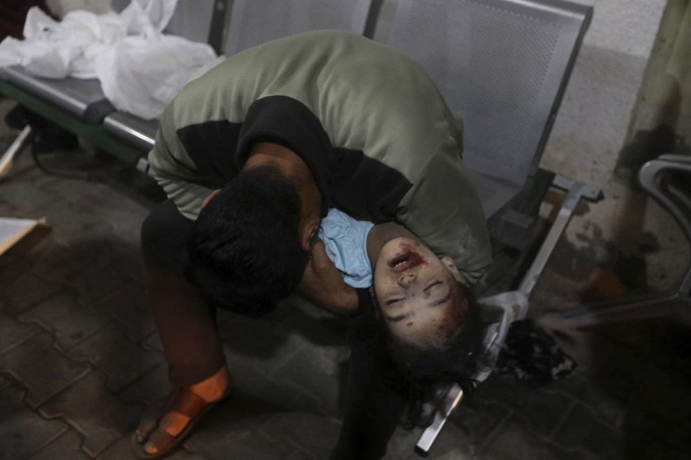 EDS NOTE: GRAPHIC CONTENT - A Palestinian youth mourns his relative killed in the Israeli bombardment of the Gaza Strip, at the morgue of the Kuwaiti Hospital in Rafah refugee camp, southern Gaza Strip, early Saturday, April 20, 2024. (AP Photo/Ismael Abu Dayyah)