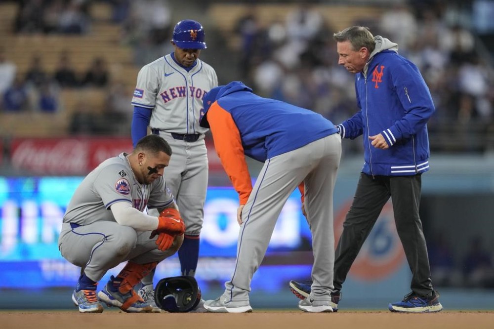 New York Mets' Francisco Alvarez, left, reacts to an injury on second base during the second inning of a baseball game against the Los Angeles Dodgers in Los Angeles, Friday, April 19, 2024. (AP Photo/Ashley Landis)