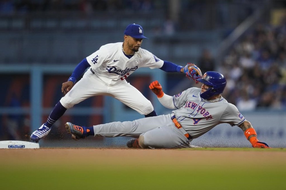New York Mets' Francisco Alvarez (4) is safe at second ahead of a throw to Los Angeles Dodgers shortstop Mookie Betts (50) during the second inning of a baseball game in Los Angeles, Friday, April 19, 2024. (AP Photo/Ashley Landis)