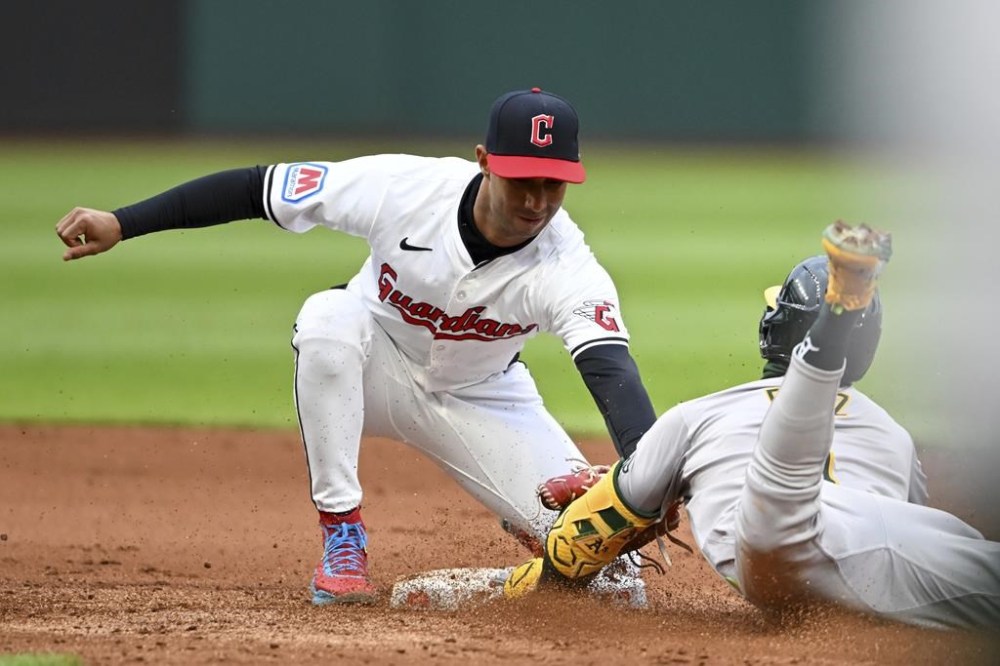 Cleveland Guardians' Brayan Rocchio tags out Oakland Athletics' Esteury Ruiz at second base as Ruiz attempted to stretch a single into a double during the fifth inning of a baseball game Saturday, April 20, 2024, in Cleveland. (AP Photo/Nick Cammett)