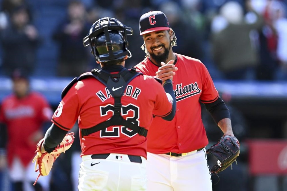 Cleveland Guardians relief pitcher Emmanuel Clase, right, and Bo Naylor (23) celebrate after their win over the Oakland Athletics in a baseball game, Sunday, April 21, 2024, in Cleveland. (AP Photo/Nick Cammett)