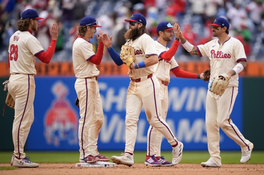 Philadelphia Phillies' Alec Bohm, from left, Bryson Stott, Brandon Marsh, Trea Turner and Nick Castellanos celebrate after winning a baseball game against the Chicago White Sox, Sunday, April 21, 2024, in Philadelphia. (AP Photo/Matt Slocum)
