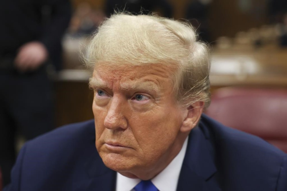 Former president Donald Trump, center, awaits the start of proceedings at Manhattan criminal court, Monday, April 22, 2024, in New York. Opening statements in Donald Trump's historic hush money trial are set to begin. Trump is accused of falsifying internal business records as part of an alleged scheme to bury stories he thought might hurt his presidential campaign in 2016. (AP Photo/Yuki Iwamura, Pool)