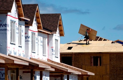 HomeStars' annual Reno Report for 2023 found the average household spend on renovations was $12,300, down from $13,000 in 2022 and forecast to fall to $10,264 this year. A builder carries a sheet of wood on the roof of a home in a new subdivision in the Ottawa suburb of Kanata, Ont., Friday, July 30, 2021. THE CANADIAN PRESS/Justin Tang