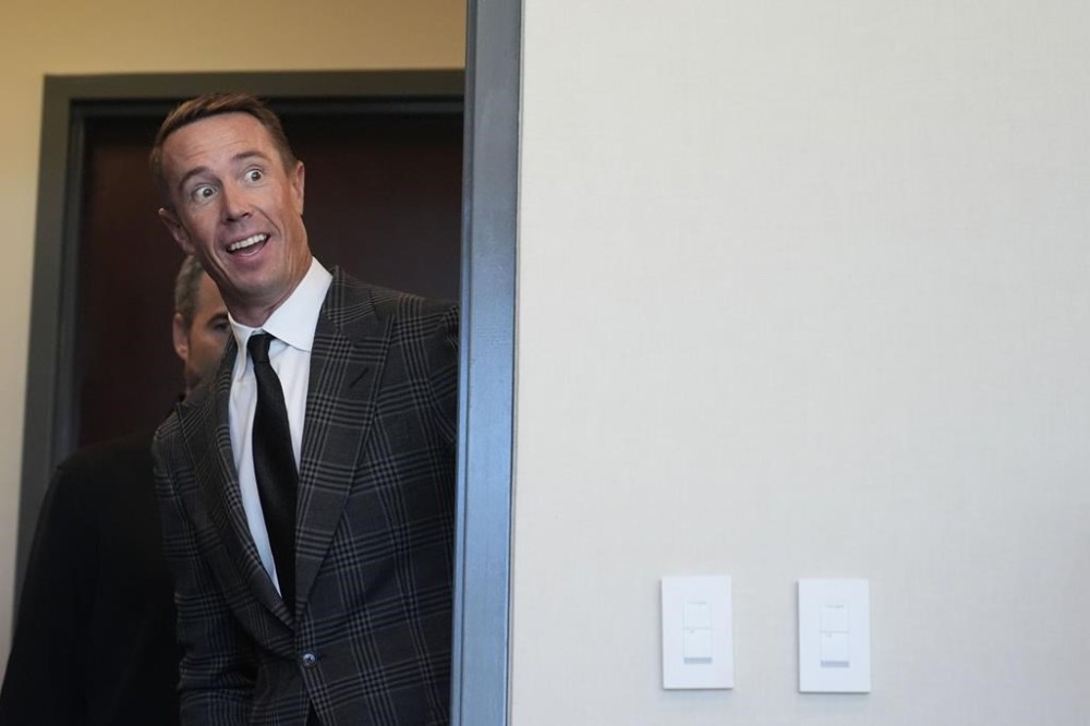 Former Atlanta Falcons quarterback Matt Ryan looks into the media room and sees former teammates Brian Finneran, Michael Jenkins and Todd McClure, there to support him as he announces his retirement during a news conference Monday, April 22, 2024, in Flowery Branch, Ga. (AP Photo/Brynn Anderson)