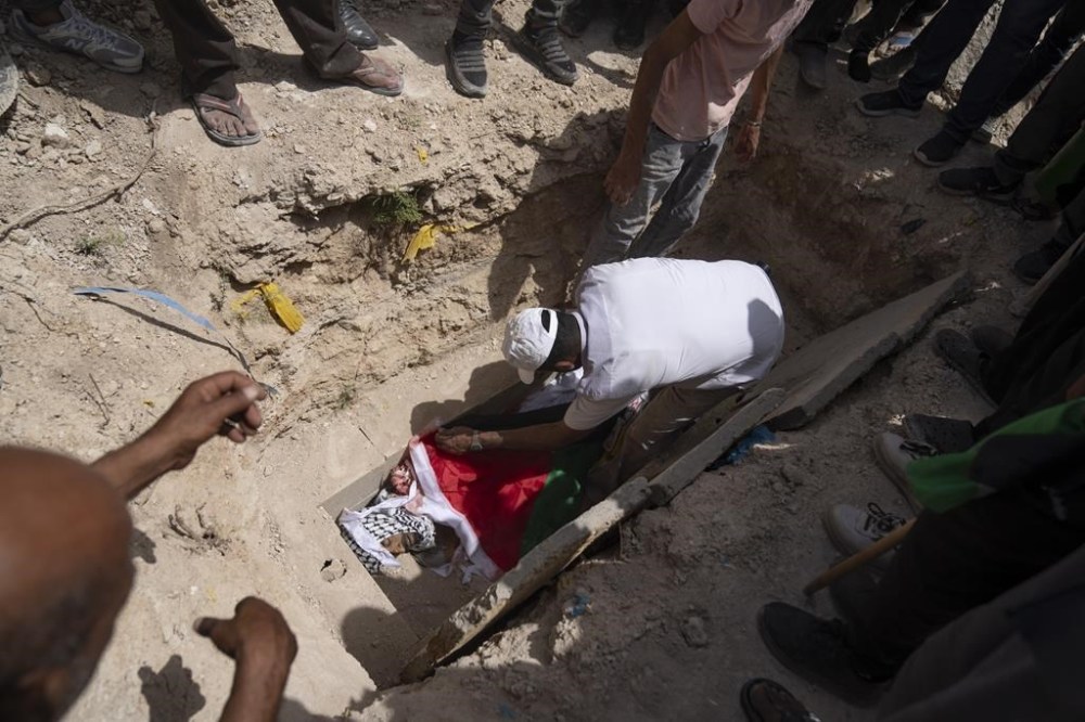 Mourners bury the body of Palestinian Shadi Jalaita, 44, at the cemetery, during his funeral in the West Bank city of Jericho Tuesday, April 23, 2024. Israeli forces shot dead a Palestinian man early Tuesday in the West Bank city of Jericho, an eyewitness and Palestinian officials said. The Palestinian Health Ministry said he suffered a fatal gunshot wound to the chest. (AP Photo/Nasser Nasser)