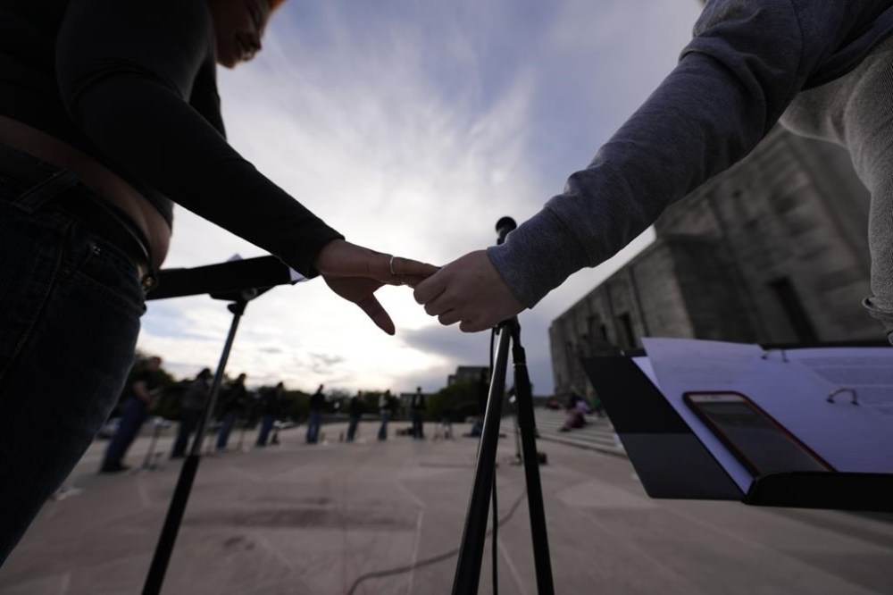 FILE - Benjamin Franklin High playwriting class students hold hands as they perform their play