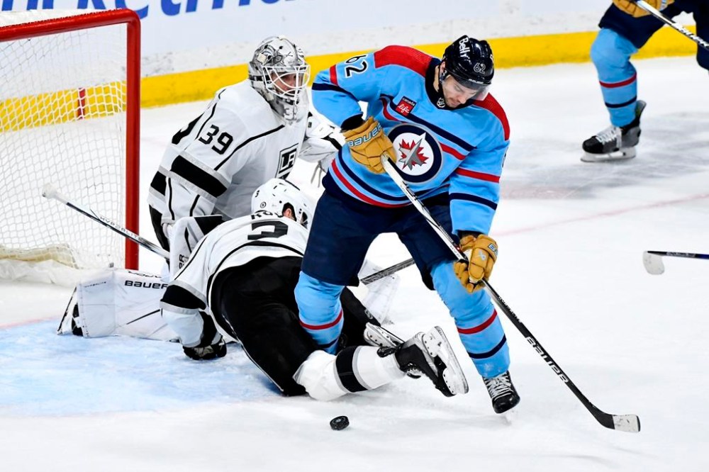 Los Angeles Kings' Matt Roy (3) gets tangled up with Winnipeg Jets' Nino Niederreiter (62) in front of Kings goaltender Cam Talbot (39) during the third period of NHL action in Winnipeg on Monday April 1, 2024. THE CANADIAN PRESS/Fred Greenslade