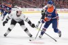 Los Angeles Kings' Jordan Spence (21) tries to stop Edmonton Oilers' Connor McDavid during second period of Game 1 first round NHL Stanley Cup playoff hockey action in Edmonton, Monday, April 22, 2024. THE CANADIAN PRESS/Jason Franson