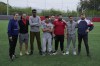 The two-time FIFA Player of the Year Carli Lloyd, left, former US soccer player Cobi Jones, second left, US Ambassador to Greece George James Tsunis, center background, pose with young migrants and members of NGOs at Olympiacos Training Center in Athens, Monday, April 22, 2024. Elite American athletes and coaches, including Lloyd and Jones, take part in the 2024 spring roster of U.S. Soccer Sports Envoys organized by the U.S. Department of State. (AP Photo/Thanassis Stavrakis)