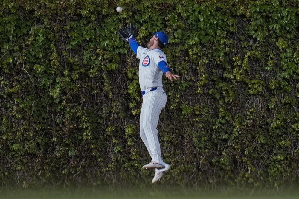Chicago Cubs center fielder Cody Bellinger struggles to catch a fly ball from Houston Astros' Yainer Diaz as it bounces off the ivy during the fourth inning of a baseball game Tuesday, April 23, 2024, in Chicago. (AP Photo/Erin Hooley)