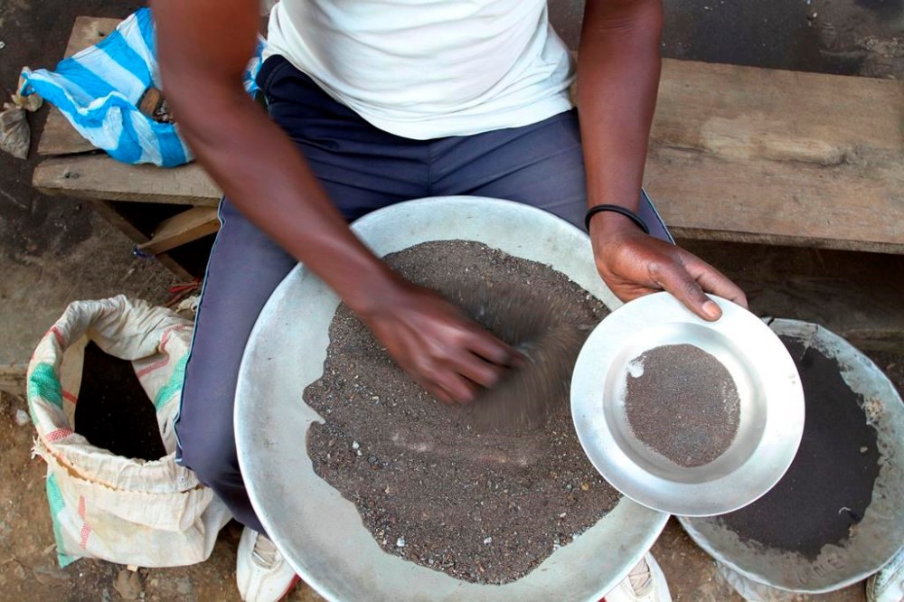 FILE - A Congolese miner sifts through ground rocks to separate out the cassiterite, the main ore that's processed into tin, in the town of Nyabibwe, eastern Congo, Aug. 16, 2012. Congo’s government is questioning Apple about the tech company’s knowledge of “blood minerals” from a conflict zone in the African country that could be smuggled into supply chains. A group of international lawyers representing Congo said Thursday, April 25, 2024, that it sent letters to Apple’s CEO Tim Cook and its French subsidiary this week raising concerns about human rights violations involving the minerals extracted from mines in the country’s war-torn east. (AP Photo/Marc Hofer, File)