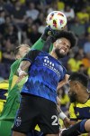 Nashville SC goalkeeper Joe Willis, left, punches the ball away from San Jose Earthquakes defender Rodrigues, center, during the first half of an MLS soccer match Saturday, April 27, 2024, in Nashville, Tenn. (AP Photo/George Walker IV)