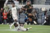 Los Angeles FC forward Denis Bouanga, top right, shoots over Portland Timbers defender Kamal Miller, bottom, during the first half of an MLS soccer match Saturday, April 27, 2024, in Los Angeles. (AP Photo/Marcio Jose Sanchez)