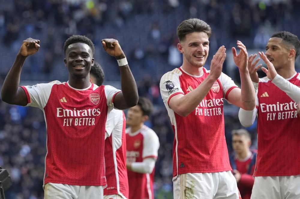 Arsenal's Bukayo Saka and Declan Rice celebrate at the end of the English Premier League soccer match between Tottenham Hotspur and Arsenal at the Tottenham Hotspur Stadium in London, England, Sunday, April 28, 2024. (AP Photo/Kin Cheung)