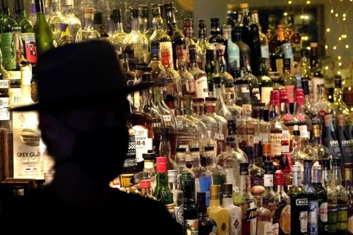 FILE - Bottles of alcohol sit on shelves at a bar in Houston on June 23, 2020. Moderate drinking was once thought to have benefits for the heart, but better research methods starting in the 2010s have thrown cold water on that. (AP Photo/David J. Phillip, File)