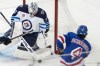 Winnipeg Jets goaltender Connor Hellebuyck (37) makes the save against New York Rangers defenseman Braden Schneider (4) during the third period of an NHL hockey game, Tuesday, March 19, 2024, at Madison Square Garden in New York. Hellebuyck, Thatcher Demko of the Vancouver Canucks and Sergei Bobrovsky of the Florida Panthers are the three finalists for this season's Vezina Trophy. THE CANADIAN PRESS/AP-Mary Altaffer