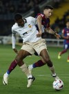 Barcelona's Robert Lewandowski fights for the ball with Valencia's Cristhian Mosquera during a Spanish La Liga soccer match between Barcelona and Valencia at the Olimpic Lluis Companys stadium in Barcelona, Spain, Monday, April 29, 2024. (AP Photo/Joan Monfort)