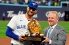 Toronto Blue Jays' Kevin Kiermaier receives his golden glove award from Steve Cohen, director of pro baseball services at Rawlings, during a pregame ceremony prior to first inning interleague MLB baseball action against the Colorado Rockies, in Toronto, Friday, April 12, 2024. THE CANADIAN PRESS/Frank Gunn