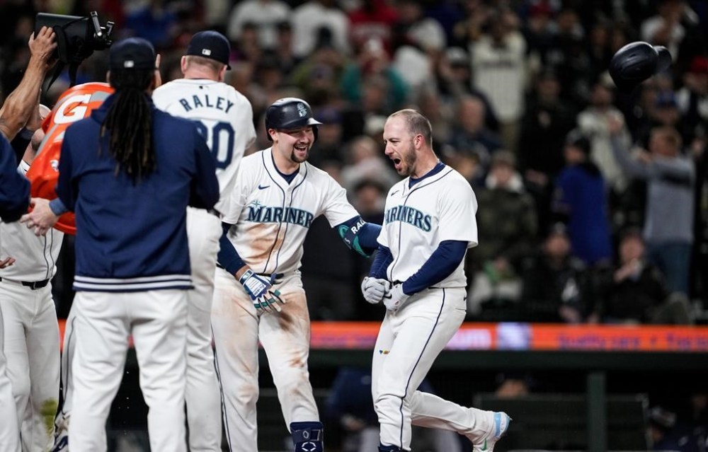 Seattle Mariners designated hitter Mitch Garver, right, throws his batting helmet as he celebrates hitting a two-run walk-off home run against the Atlanta Braves with teammates, including Cal Raleigh, second from right, in a baseball game Monday, April 29, 2024, in Seattle. (AP Photo/Lindsey Wasson)