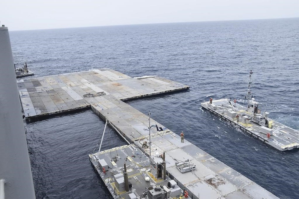 This undated photo released early Tuesday, April 30, 2024, by the U.S. military's Central Command shows construction off a floating pier in the Mediterranean Sea off the Gaza Strip. A U.S. Navy ship involved in the American-led effort to bring more aid into the besieged Gaza Strip is off shore from the enclave, slowly building out a floating platform for the operation, satellite photos analyzed Monday, April 29, 2024, by The Associated Press show. (U.S. military's Central Command via AP)