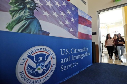 FILE - People arrive before the start of a naturalization ceremony at the U.S. Citizenship and Immigration Services Miami Field Office in Miami, Aug. 17, 2018. Authorities say lottery bids for highly-educated worker visas plunged nearly 40% this year, claiming success against people who were 