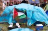 Pro-Palestinian activists fly a flag in an encampment set up on McGill University's campus in Montreal, Monday, April 29, 2024. THE CANADIAN PRESS/Christinne Muschi