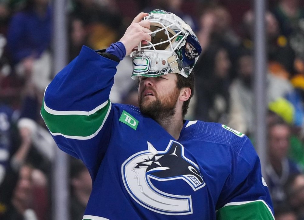 Vancouver Canucks goalie Thatcher Demko puts his mask back on after it was struck by a puck during the second period in Game 1 of an NHL hockey Stanley Cup first-round playoff series against the Nashville Predators in Vancouver on Sunday, April 21, 2024. THE CANADIAN PRESS/Darryl Dyck