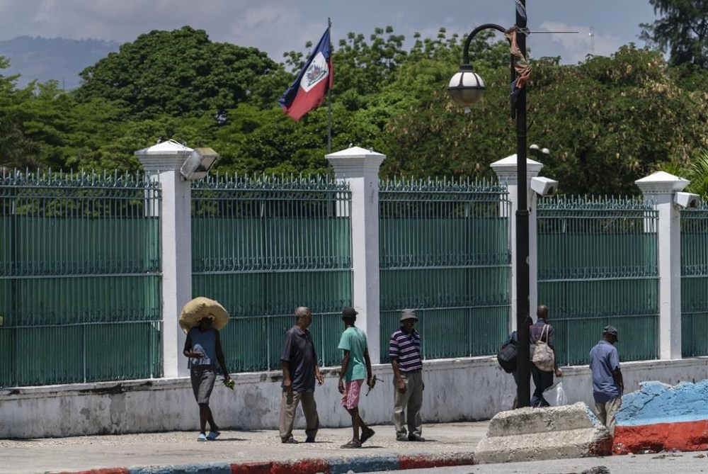 People walk past the National Nalace in Port-au-Prince, Haiti, Tuesday, April 23, 2024. (AP Photo/Ramon Espinosa)