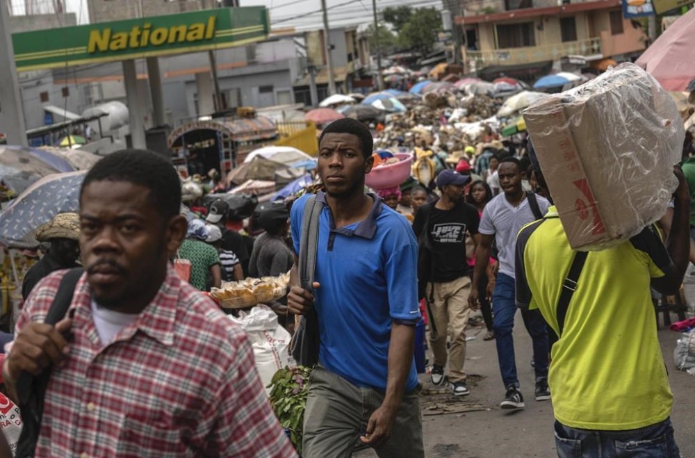 People walk through a street market in Port-au-Prince, Haiti, Friday, April 26, 2024. (AP Photo/Ramon Espinosa)