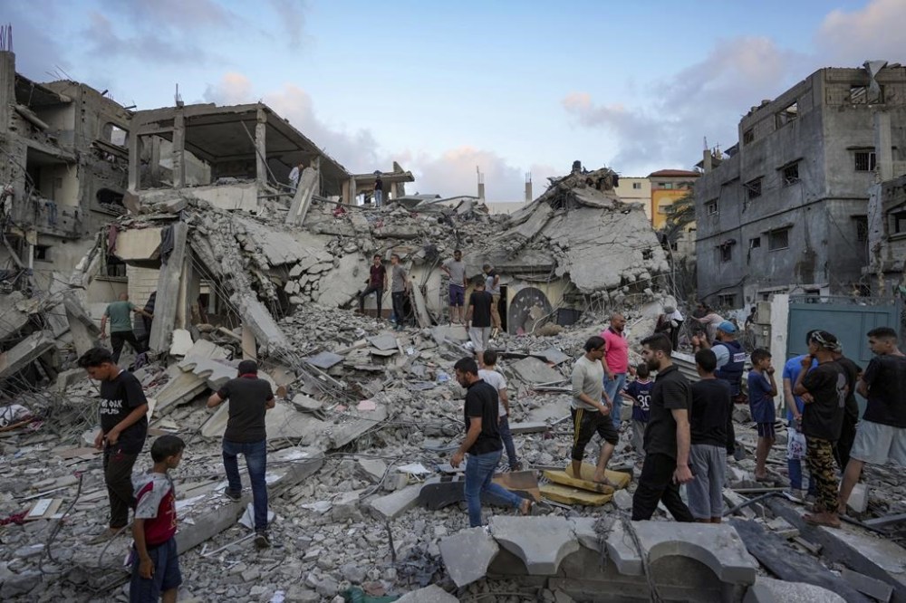Palestinians look at the destruction after an Israeli airstrike in Deir al Balah, Gaza Strip, Tuesday, April 30, 2024. (AP Photo/Abdel Kareem Hana)
