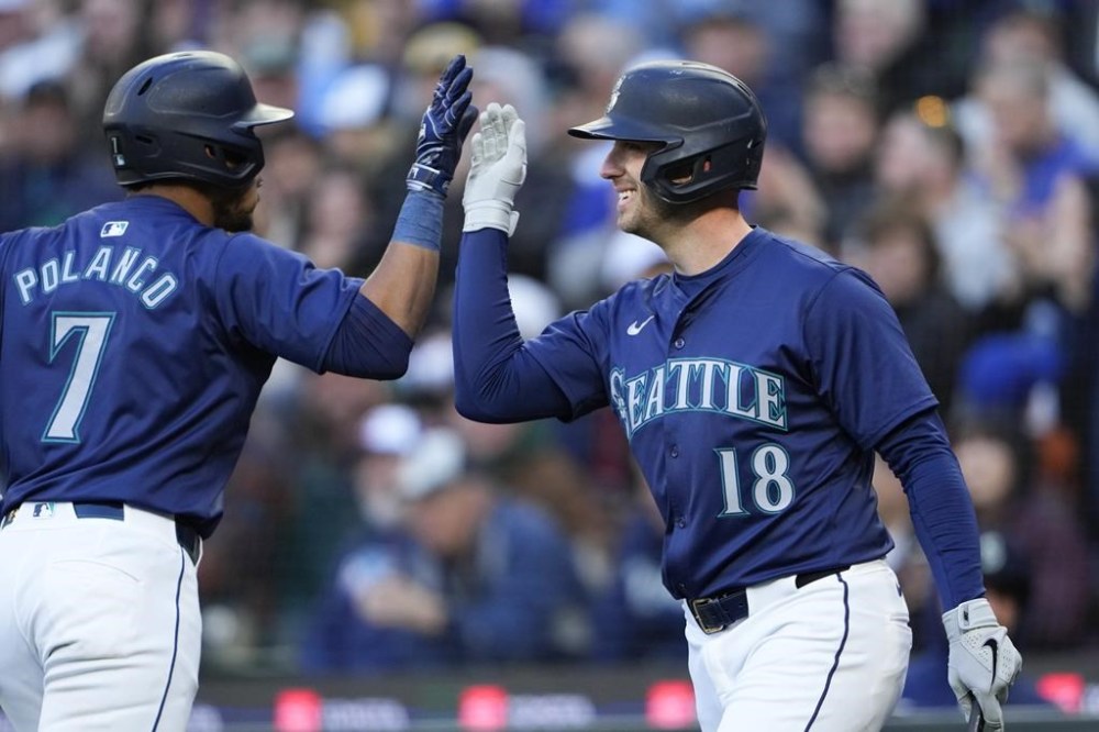 Seattle Mariners' Jorge Polanco is greeted by Mitch Garver (18) after Polanco hit a two-run home run against the Atlanta Braves during the third inning of a baseball game Tuesday, April 30, 2024, in Seattle. (AP Photo/Lindsey Wasson)
