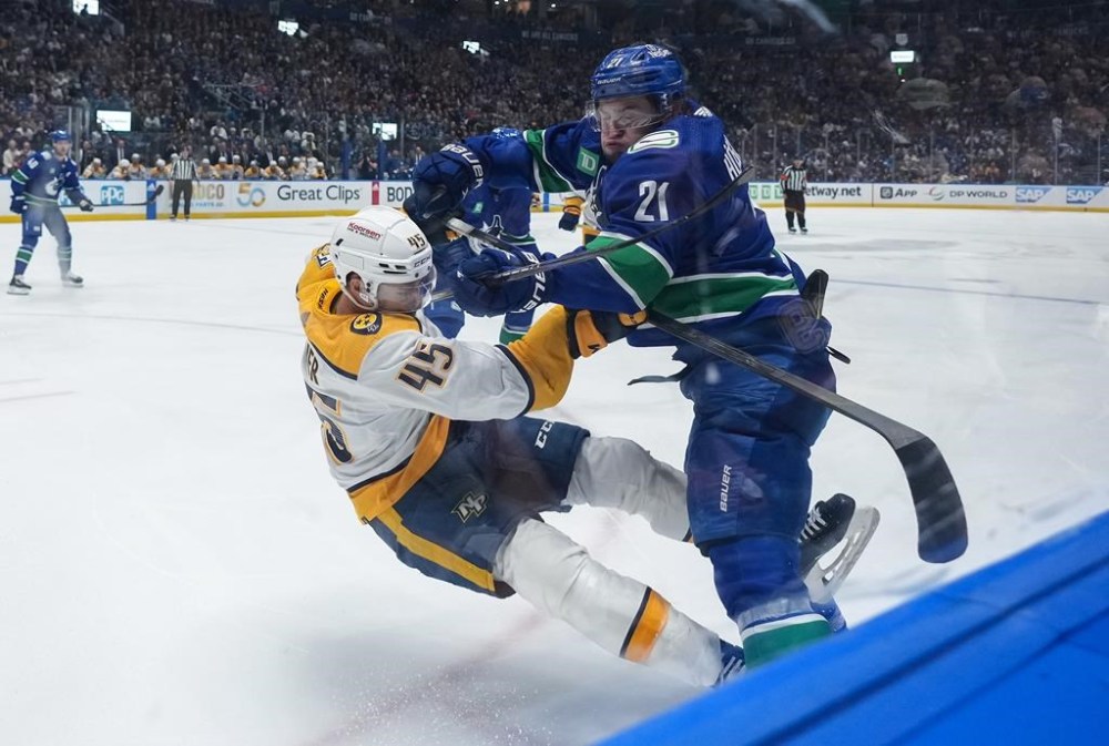 Vancouver Canucks' Nils Hoglander (21) checks Nashville Predators' Alexandre Carrier (45) during the first period in Game 5 of an NHL hockey Stanley Cup first-round playoff series, in Vancouver, on Tuesday, April 30, 2024. THE CANADIAN PRESS/Darryl Dyck