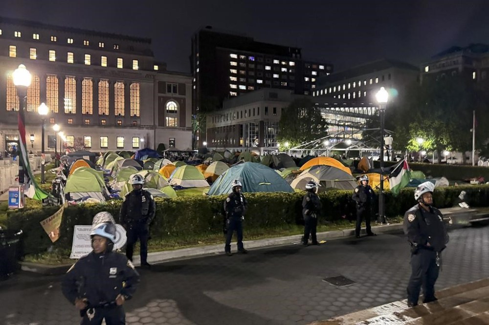 In this photo released by the New York City Police Department, New York Police officers surround the south lawn as protesters are cleared from Hamilton Hall and the encampment, Tuesday, April 30, 2024, in New York. Hundreds of police officers swept into Columbia University on Tuesday night to end a pro-Palestinian occupation of the administration building and sweep away a protest encampment, acting after the school's president said there was no other way to ensure safety and restore order on campus. (NYPD via AP)