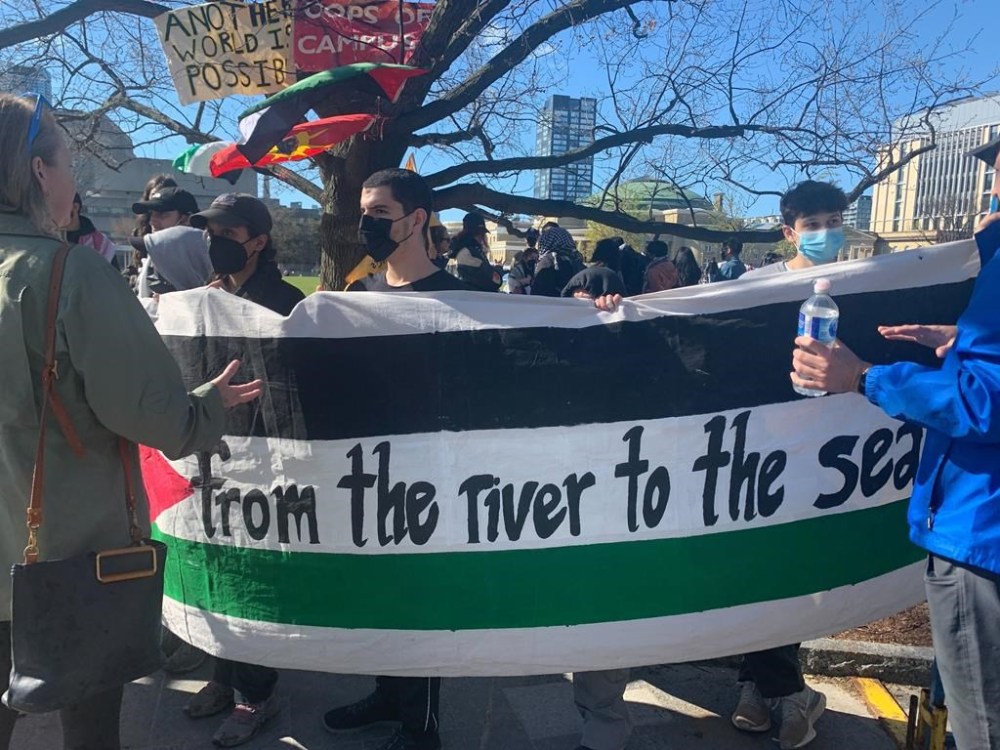 Protesters hold up a sign at a pro-Palestinian encampment set up on the University of Toronto campus on Thursday, May 2, 2024. THE CANADIAN PRESS/Fakiha Baig