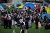 A pro-Palestinian activist group that has been promoting a protest encampment at the University of B.C. says its international co-ordinator was arrested and released with an order not to attend any protests for the next five months. People gather and pitch tents at a pro-Palestinian student encampment at the University of British Columbia campus in Vancouver, Monday, April. 29, 2024. THE CANADIAN PRESS/Ethan Cairns