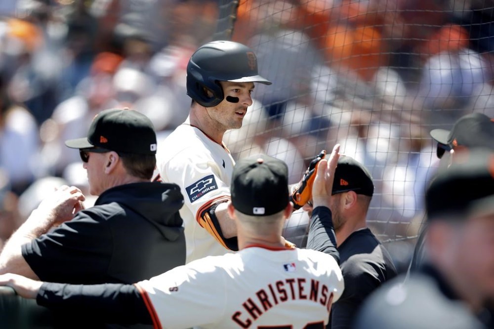 San Francisco Giants' Mike Yastrzemski (5) high-fives coaches as he returns to the dugout after hitting a solo home run off Pittsburgh Pirates pitcher Jared Jones during the third inning of a baseball game Sunday, April 28, 2024, in San Francisco. (Carlos Avila Gonzalez/San Francisco Chronicle via AP)