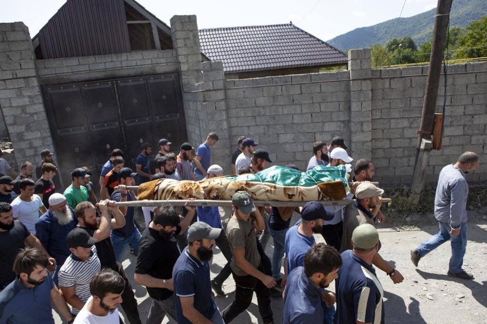 FILE - In this Aug. 29, 2019 file photo, people carry the body of Zelimkhan Khangoshvili at his funeral in Georgia’s Pankisi Gorge valley. Khangoshvili fought Russian forces during a separatist war in the Chechnya region of southern Russia. After the war, he fled to Germany after surviving two assassination attempts but was shot to death in 2019 in Berlin. (AP Photo/Zurab Tsertsvadze, File)