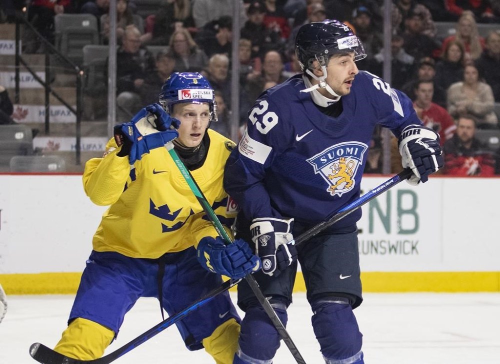 Sweden's Adam Engstrom and Finland's Niko Huuhtanen battle for position during first period IIHF World Junior Hockey Championship quarter-final hockey action in Moncton, N.B., on January 2, 2023. THE CANADIAN PRESS/Ron Ward