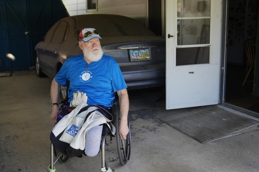 Dean Kahler, who was shot an paralyzed at Kent State University on May 4, 1970, wheels himself out of his home during an interview Thursday, May 2, 2024, in Plain Township, Ohio. (AP Photo/Sue Ogrocki)