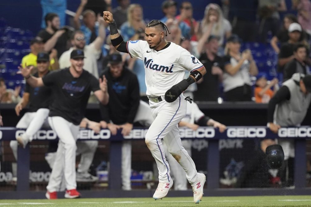 Miami Marlins' Luis Arraez scores the winning run on a hit by Jesús Sánchez during the 10 inning of a baseball game against the Colorado Rockies, Thursday, May 2, 2024, in Miami. The Marlins defeated the Rockies 5-4. (AP Photo/Marta Lavandier)