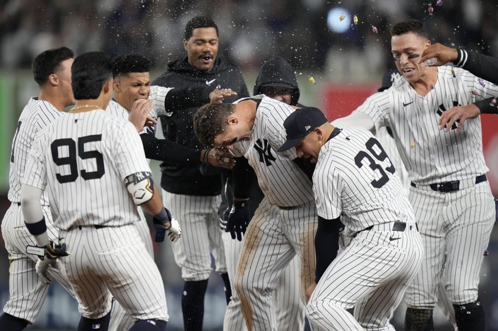 New York Yankees' Anthony Rizzo, center, celebrates with teammates after hitting a walk-off RBI single during the ninth inning of a baseball game against the Detroit Tigers, Friday, May 3, 2024, in New York. The Yankees won 2-1. (AP Photo/Frank Franklin II)