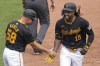 Pittsburgh Pirates' Oneil Cruz (15) is greeted by third base coach Mike Rabel, left, as he rounds third after hitting a two-run home run off Colorado Rockies starting pitcher Ryan Feltner during the sixth inning of a baseball game in Pittsburgh, Sunday, May 5, 2024. (AP Photo/Gene J. Puskar)