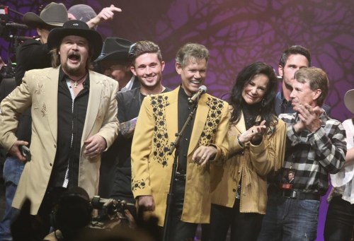 FILE - Travis Tritt, left, Randy Travis, center left, Mary Travis, center right, and Ricky Traywick, right, appear on stage at the 