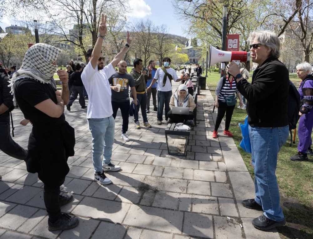 Palestinian supporters try to block an Israeli supporter, right, at the encampment on McGill University campus Monday, May 6, 2024, in Montreal. THE CANADIAN PRESS/Ryan Remiorz
