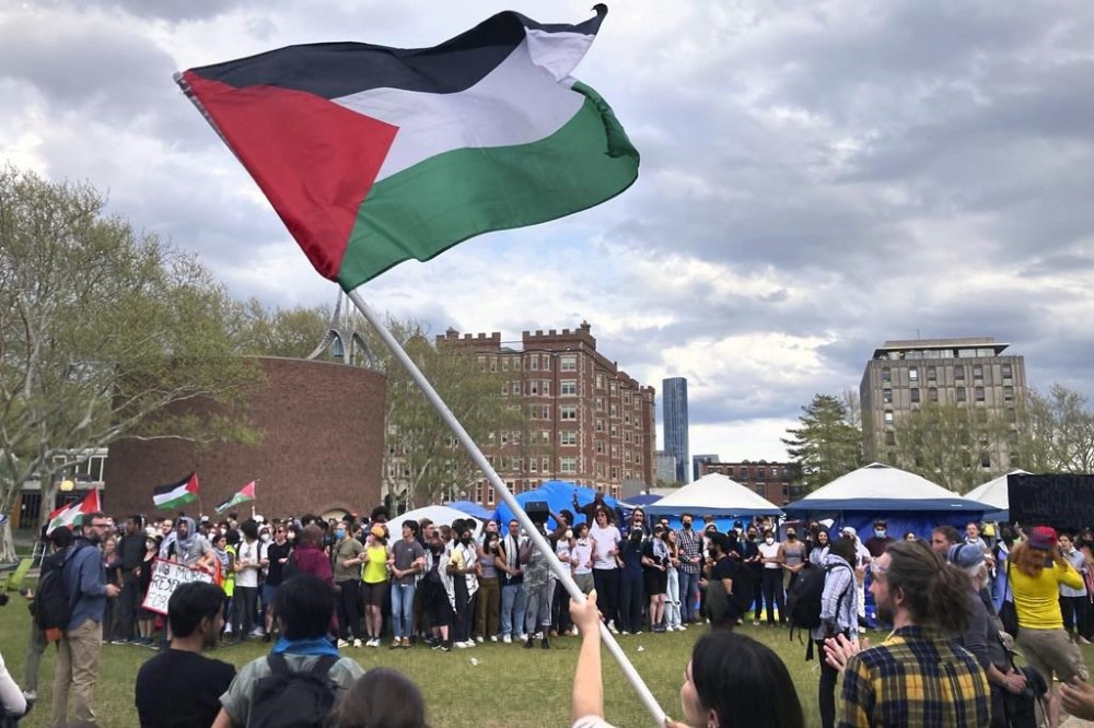Pro-Palestinian protestors link arms and take back a student encampment on the campus of the Massachusetts Institute of Technology, after a 2:30pm deadline passed to leave the encampment, Monday May 6, 2024, in Cambridge, Mass. (AP Photo/Steve LeBlanc)