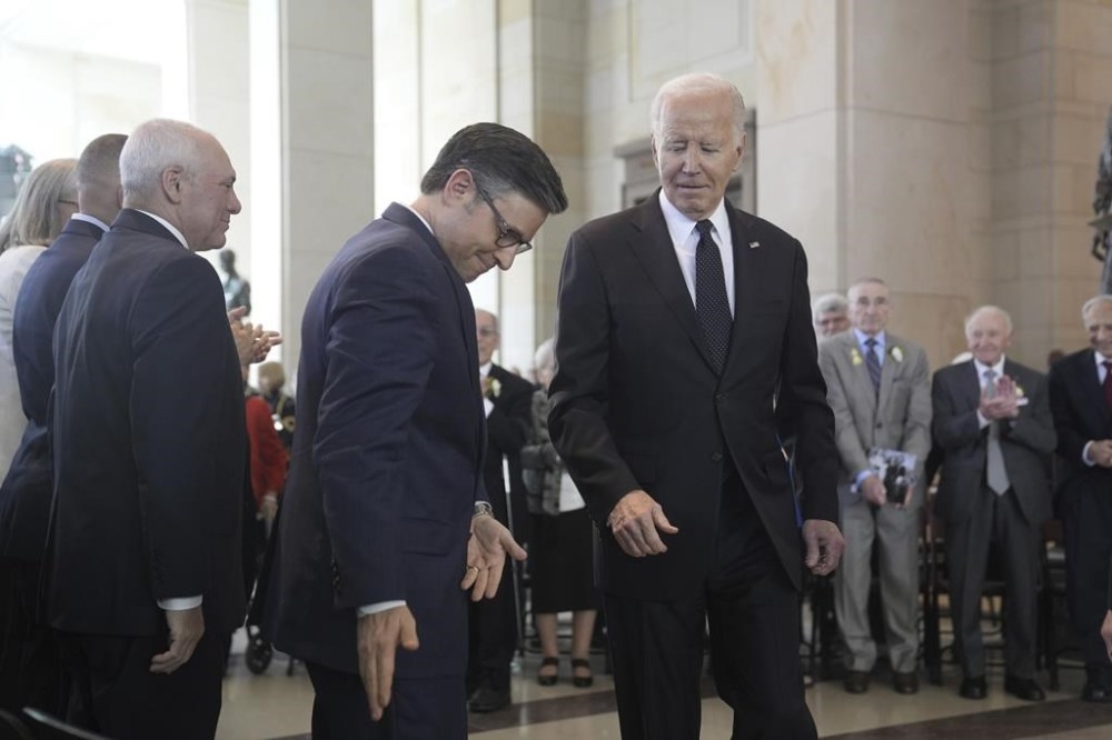 President Joe Biden walks to sit beside Speaker of the House Mike Johnson, R-La., after speaking at the U.S. Holocaust Memorial Museum's Annual Days of Remembrance ceremony at the U.S. Capitol, Tuesday, May 7, 2024 in Washington. (AP Photo/Evan Vucci)