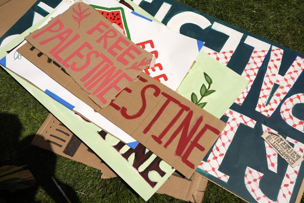 Placards lay on the ground outside an entrance to a building at Rhode Island School of Design that has been partially taken over by students and supporters, Tuesday, May 7, 2024, in Providence, R.I. The activists are demanding that RISD condemn Israel's war effort in Gaza, and that the school divest from investments that benefit Israel. (AP Photo/Steven Senne)