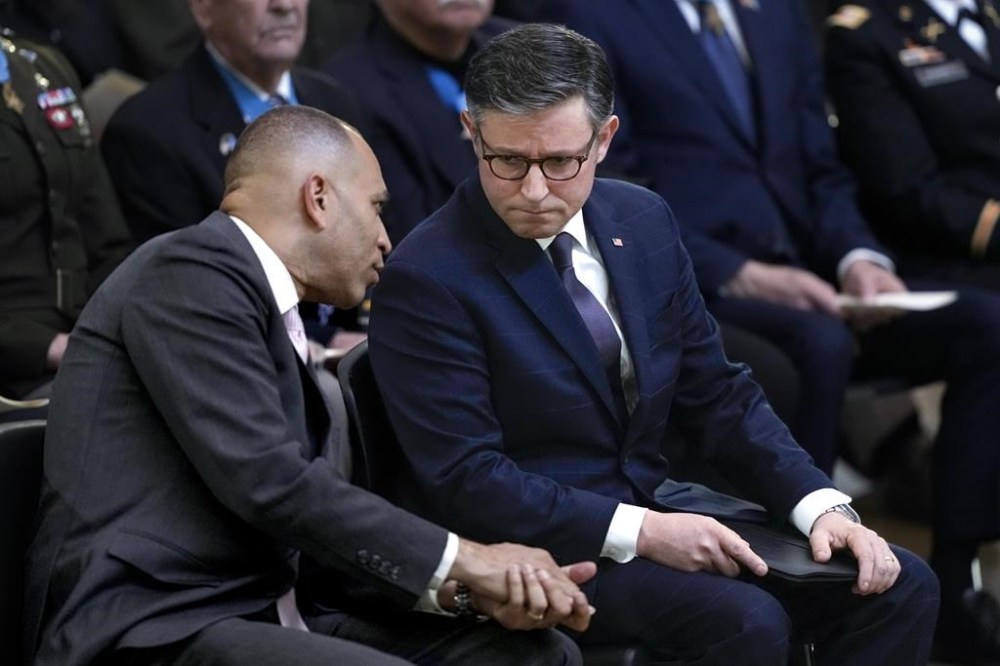 FILE—House Minority Leader Hakeen Jeffries, D-N.Y., left, and House Speaker Mike Johnson of La., confer during a ceremony at the U.S. Capitol Monday, April 29, 2024, in Washington. Rep. Marjorie Taylor Greene, R-Ga., a staunch ally of former President Donald Trump, is threatening to oust House Speaker Mike Johnson, R-La., from his leadership post because of his reliance on support from Democrats led by Hakeem Jeffries. (AP Photo/J. Scott Applewhite, file)